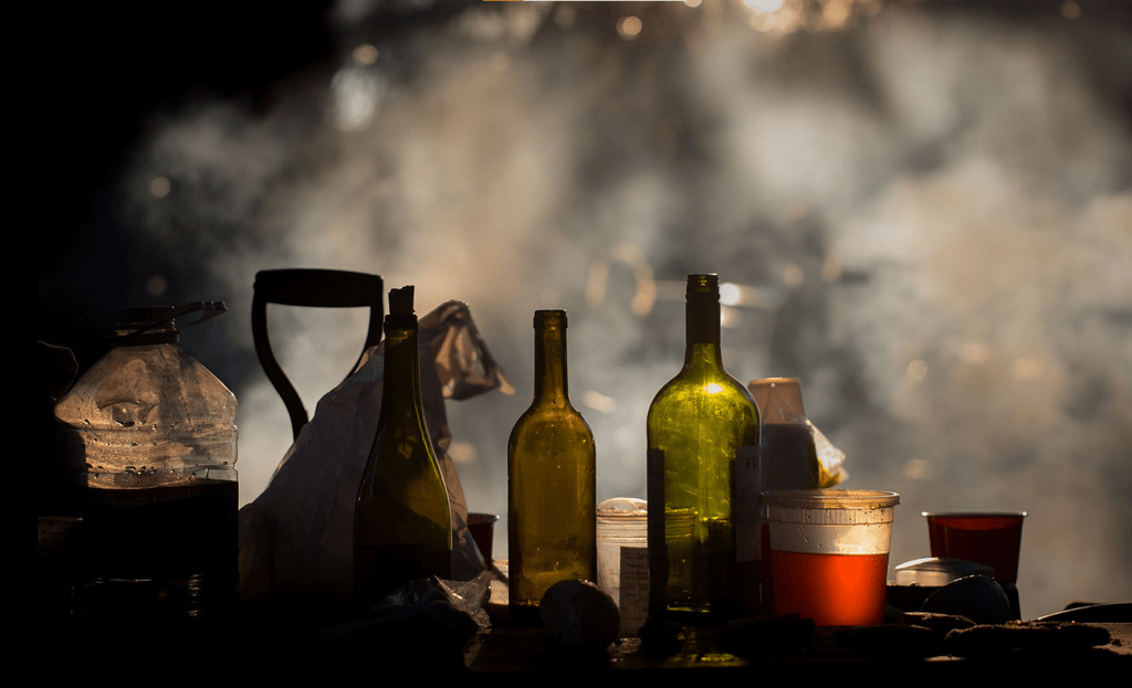 photo of a table with bottles and a smoky background
